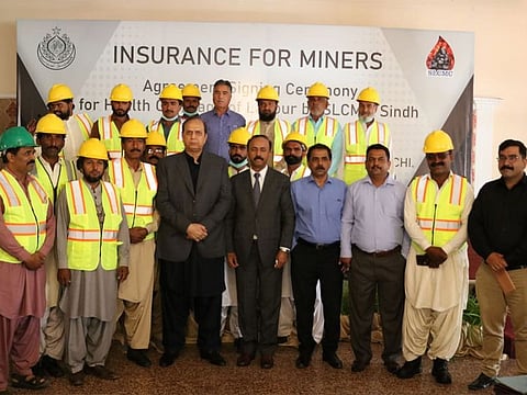Sindh Energy Minister Imtiaz Ahmed Sheikh pictured with miners associated with Lakhra coalfields at the ceremony to extend health insurance coverage to them.  