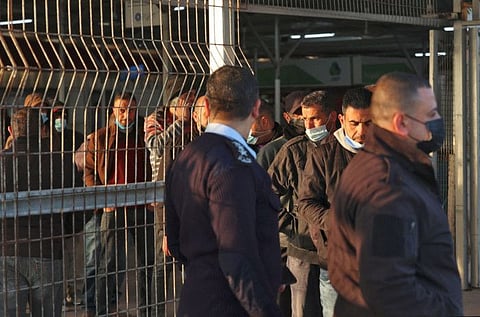 Palestinian workers leave the last station in Beit Hanun in the northern Gaza Strip,  before reaching Israel through the Erez crossing to work, on February 23, 2022. 