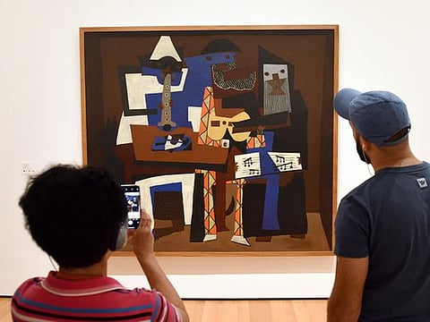 Visitors near the Pablo Picasso Three Musicians painting in Museum of Modern Art in New York City