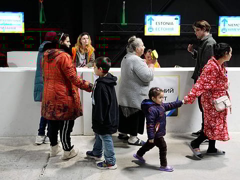 People queue to register for a transport to different countries in a refugee center in Nadarzyn, near Warsaw, Poland, on Friday, March 25, 2022.