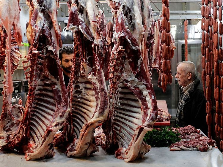 In this file photo taken on January 26, 2021 a butcher waits for costumers at a market in the city of Tripoli.