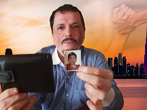 Dubai-based Gopal Sriniwasan holding up the wallet and the treasured photo of his daughter Nikita after Dubai Police traced and recovered his lost belongings.