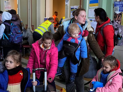 Ukrainian Marina Stadnik from Kramatosrk, waits with her four children at a train station in Przemysl, southeastern Poland, Monday, March 28, 2022.