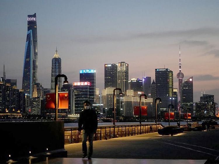 A man walks in front of Lujiazui financial district, seen across the Huangpu river at dusk, amid the lockdown in Pudong area in Shanghai. R