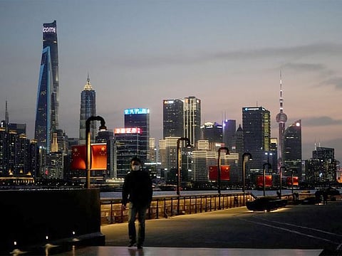 A man walks in front of Lujiazui financial district, seen across the Huangpu river at dusk, amid the lockdown in Pudong area in Shanghai. R