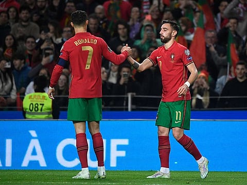 Portugal's midfielder Bruno Fernandes (right) with Cristiano Ronaldo.
