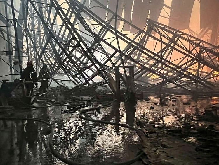 Rescuers work at a site of a food warehouse damaged by shelling, in Brovary, Kyiv region. 