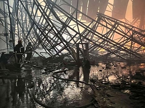 Rescuers work at a site of a food warehouse damaged by shelling, in Brovary, Kyiv region. 