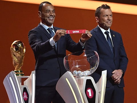 Former Brazilian footballer and World Cup winner Cafu holds the card showing the name of Qatar during the draw for the 2022 World Cup in Qatar at the Doha Exhibition and Convention Center.