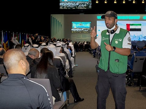 Yehia Saleh Al Ammari, a sign language interpreter from Dubai Police, assists a visitor at World Government Summit in Expo 2020 Dubai.