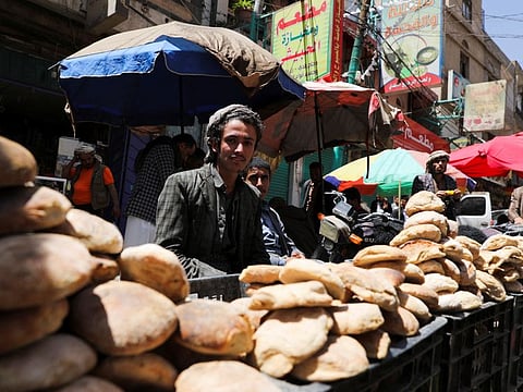 Vendors selling bread wait for customers on a street  in Sana'a on April 1, 2022. 