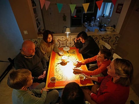 Peter Bankov, a Russian citizen who was born in Belarus and worked professionally in Russia, his Russian wife Yulia Fedulova and their daughter Sofi,10, drink tea with a Ukrainian refugee Yulia Sarycheva, and her sons Sergey,15, Sava,12, and Serafin, 8, inside their house in Prague, Czech Republic, March 30, 2022.