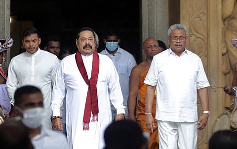 Sri Lanka’s former President Mahinda Rajapaksa, centre, leaves with his younger brother, President Gotabaya Rajapaksa, right, after being sworn in as the prime minister at Kelaniya Royal Buddhist temple in Colombo, Sri Lanka, Sunday, Aug. 9, 2020.