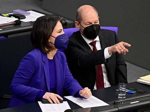German Chancellor Olaf Scholz chats with Foreign Minister Annalena Baerbock during a debate at the Bundestag (lower house of parliament) in Berlin on April 7, 2022.  