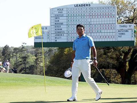 Defending champion Hideki Matsuyama walks back from the 18th hole after completing his first round at Augusta Masters on Friday.