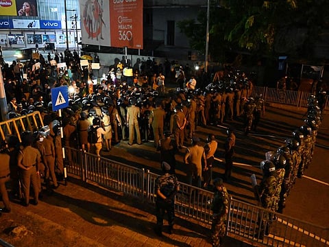 Anti-riot police officers attempt to block protesters during a rally against the rise of prices and shortage of fuel at the entrance road of the Sri Lanka prime minister's official residence in Colombo on April 7, 2022.