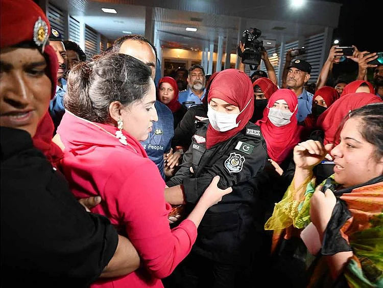 Female police officers detain supporters of Imran Khan’s party outside parliament house in Islamabad