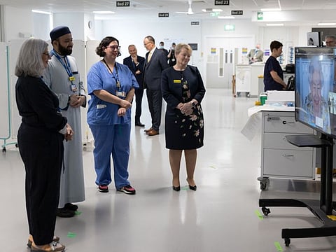 A handout photo released by Buckingham Palace on April 10, 2022, shows staff at The Royal London Hospital in east London during a video call with Britain's Queen Elizabeth II, in residence at Windsor Castle, to mark the official opening of the hospital's Queen Elizabeth Unit. 
