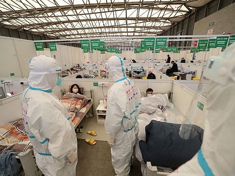 Medical workers in protective suits conduct ward rounds at Shanghai New International Exhibition Hall, which has been turned into a makeshift hospital for COVID-19 patients, in Shanghai.