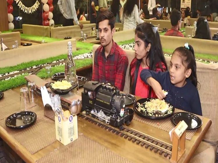 Food being served on a toy train at the Surat restaurant.