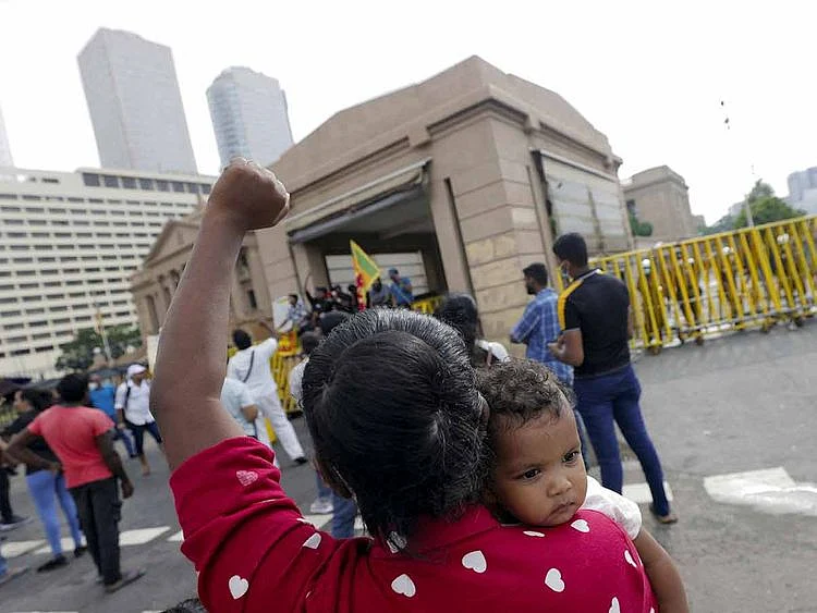 A woman carries her baby and shouts slogans