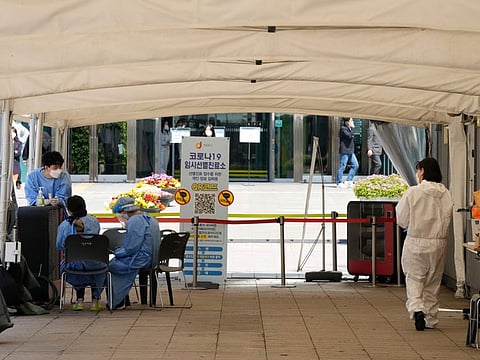 Medical workers wait for people at a temporary COVID-19 testing centre in Seoul, South Korea, Friday, April 15, 2022.