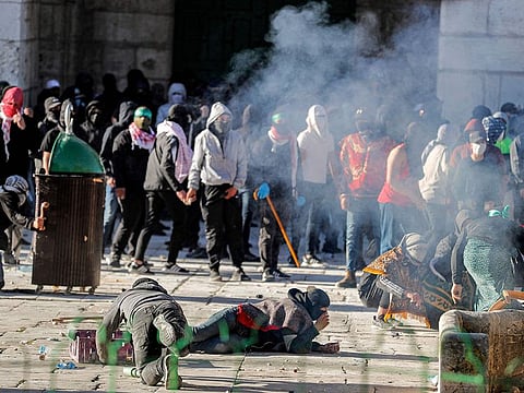 Palestinian demonstrators clash with Israeli police at Jerusalem's Al-Aqsa mosque compound on April 15, 2022.