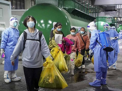 COVID-19 patients leave a makeshift hospital at the National Exhibition and Convention Center in Shanghai. 