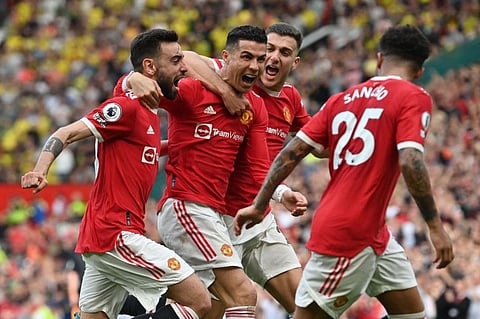 Manchester United's Portuguese striker Cristiano Ronaldo (centre) celebrates with teammates after scoring his third goal during the English Premier League match against Norwich City at Old Trafford in Manchester, north west England.