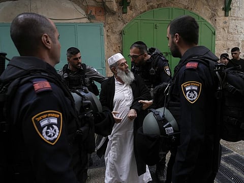 Israel police argues with a Palestinian worshipers the Old City of Jerusalem, Sunday, April 17, 2022.