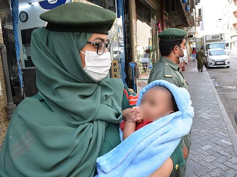 A Dubai Police official with the three-month-old infant.