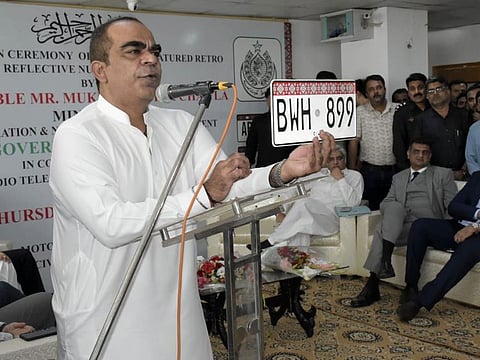 Sindh Excise and Taxation Minister, Mukesh Kumar Chawla, displays a new vehicle registration plate. 