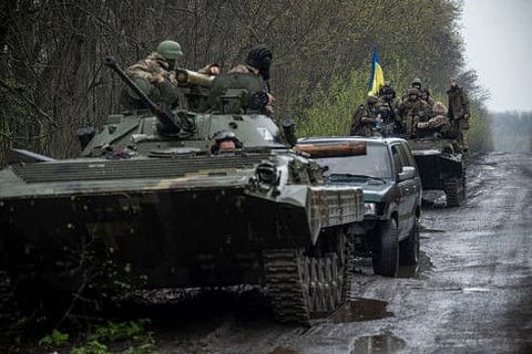Ukrainian servicemen sit atop an armoured fighting vehicle, as Russia’s attack on Ukraine continues, at an unknown location in Eastern Ukraine, in this handout picture released April 19, 2022. 