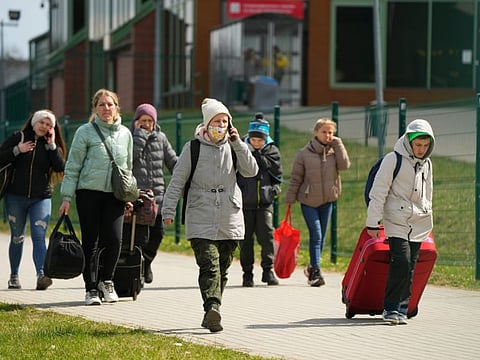 Refugees walk after fleeing the war from neighbouring Ukraine at the border crossing in Medyka, southeastern Poland, on April 12, 2022.  