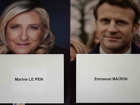 An illustration picture taken on April 20, 2022 in Lavau sur Loire shows campaign posters and ballots of French far-right party Rassemblement National (RN) candidate Marine Le Pen and La Republique en Marche (LREM) candidate for re-election Emmanuel Macron ahead of the second round of the French presidential election.  
