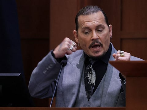 Actor Johnny Depp demonstrates how he claims his ex-wife Amber Heard punched him as he testifies during his defamation trial against Heard, at the Fairfax County Circuit Courthouse in Fairfax, Virginia, US.