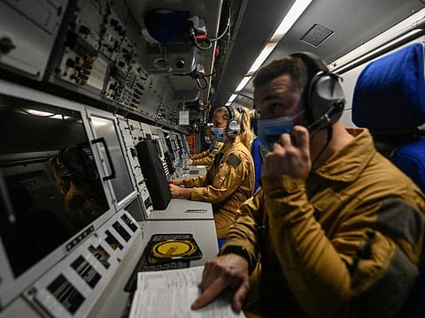 Crew members prepare for monitoring procedures before the take-off of the French Navy's Atlantique 2 long-range patrol aircraft, at the Souda NATO military air base, in the northwest of the Greek Mediterranean island of Crete, on April 20, 2022.