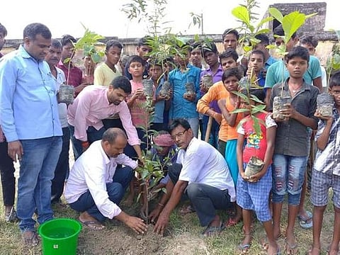 Gajendra (left) engaged in plantation drive along with the villagers and children.