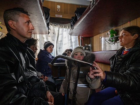 Evgueni Tichtchenko (left) and Tetiana Komissarova and their children Ivan, Ioulia, Anna and Sashko in an evacuation train to Lviv the day after arriving with a humanitarian convoy from the besieged city of Mariupol, at a railway station in the southern city of Zaporijjia on April 22, 2022. 