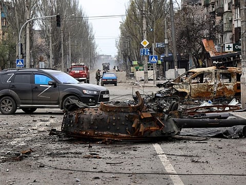 A part of a destroyed tank and a burned vehicle sit in an area controlled by Russian-backed separatist forces in Mariupol, Ukraine, Saturday, April 23, 2022. (AP Photo/Alexei Alexandrov)