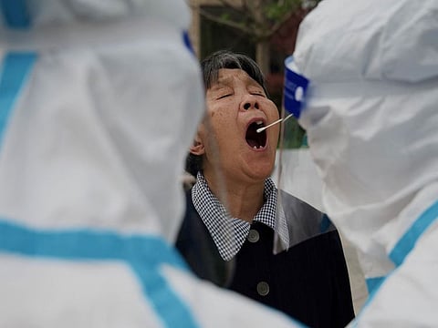 A resident has a sample taken to be tested for the Covid-19 coronavirus at a swab collection site in Beijing on April 25, 2022.