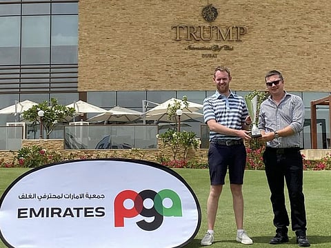 Louis Gaughan (left) of ProSports International, Jumeirah Golf Estates receiving the trophy from David Gray, CEO of the UAE PGA, after winning the 2021-2022 UAE PGA Order of Merit.