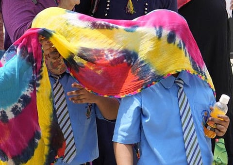 School children cover themselves with cotton clothes to protect themselves from the sun in Prayagraj, in the northern Indian state of Uttar Pradesh.