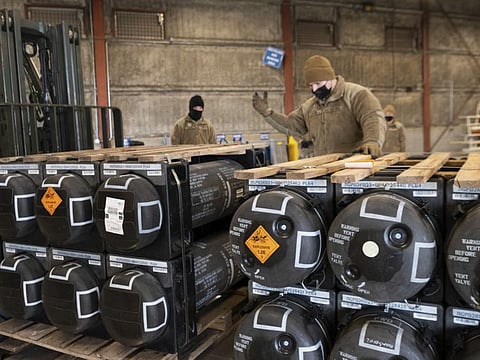 In this image provided by the US Air Force, Airmen and civilians from the 436th Aerial Port Squadron palletize ammunition, weapons and other equipment bound for Ukraine during a foreign military sales mission at Dover Air Force Base.