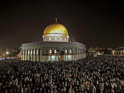 Palestinian devotees pray on Laylat Al Qadr outside the Dome of the Rock in Jerusalem's Al Aqsa Mosque compound during the Muslim fasting month of Ramadan late on April 27, 2022. 