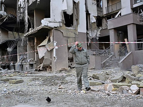 A local resident walks  by a damaged building following Russian strikes in Kyiv on April 29, 2022, amid Russian invasion of Ukraine.