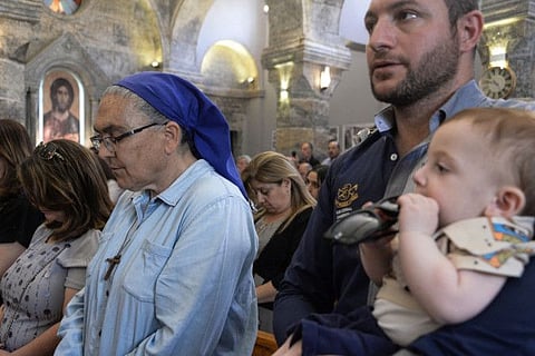 Worshippers attend mass at the Syriac Catholic Church of Mar Touma (Saint Thomas) in Iraq's northern city of Mosul, on April 30, 2022.