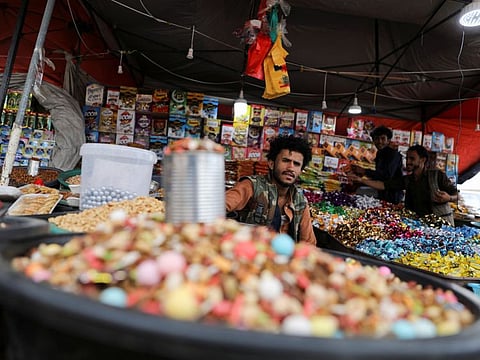 A vendor waits for customers at his sweets stall ahead of Eid al-Fitr, which marks the end of the holy month of Ramadan, in Sanaa, Yemen April 30, 2022. 
