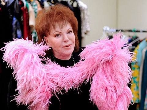 In this file photo taken on January 09, 2012 Paris night celebrity, singer, actress and businesswoman Regine poses with a long Ted Lapidus skirt drawn by Erte  with the famous "boa" at the Tajan galery in Paris. - Regine died at the age of 92, her grand-daughter told AFP on May 1, 2022. 