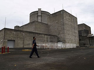 A security guard walking in front of the main gate of the Bataan Nuclear Power Plant in the town of Morong in Bataan. It costs Filipino taxpayers roughly $1 million annually in upkeep while producing zero electricity. 